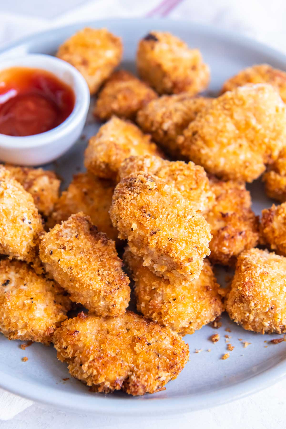 Close up of crispy air fryer chicken nuggets served with ketchup.