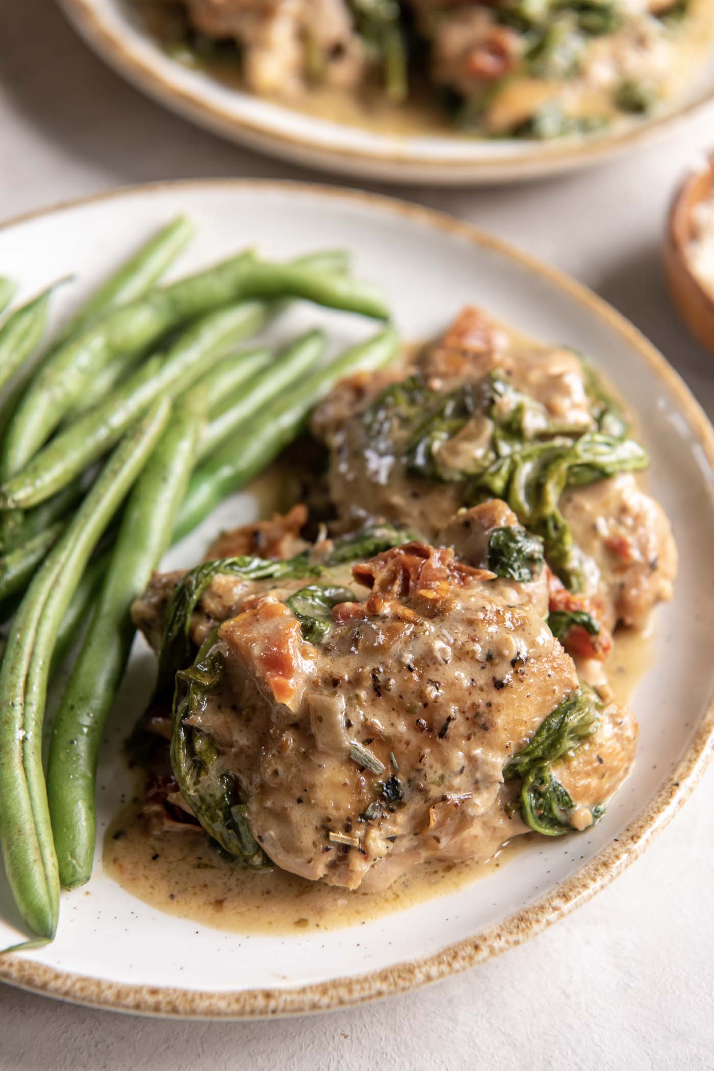 Close up of slow cooker chicken thighs served with green beans.