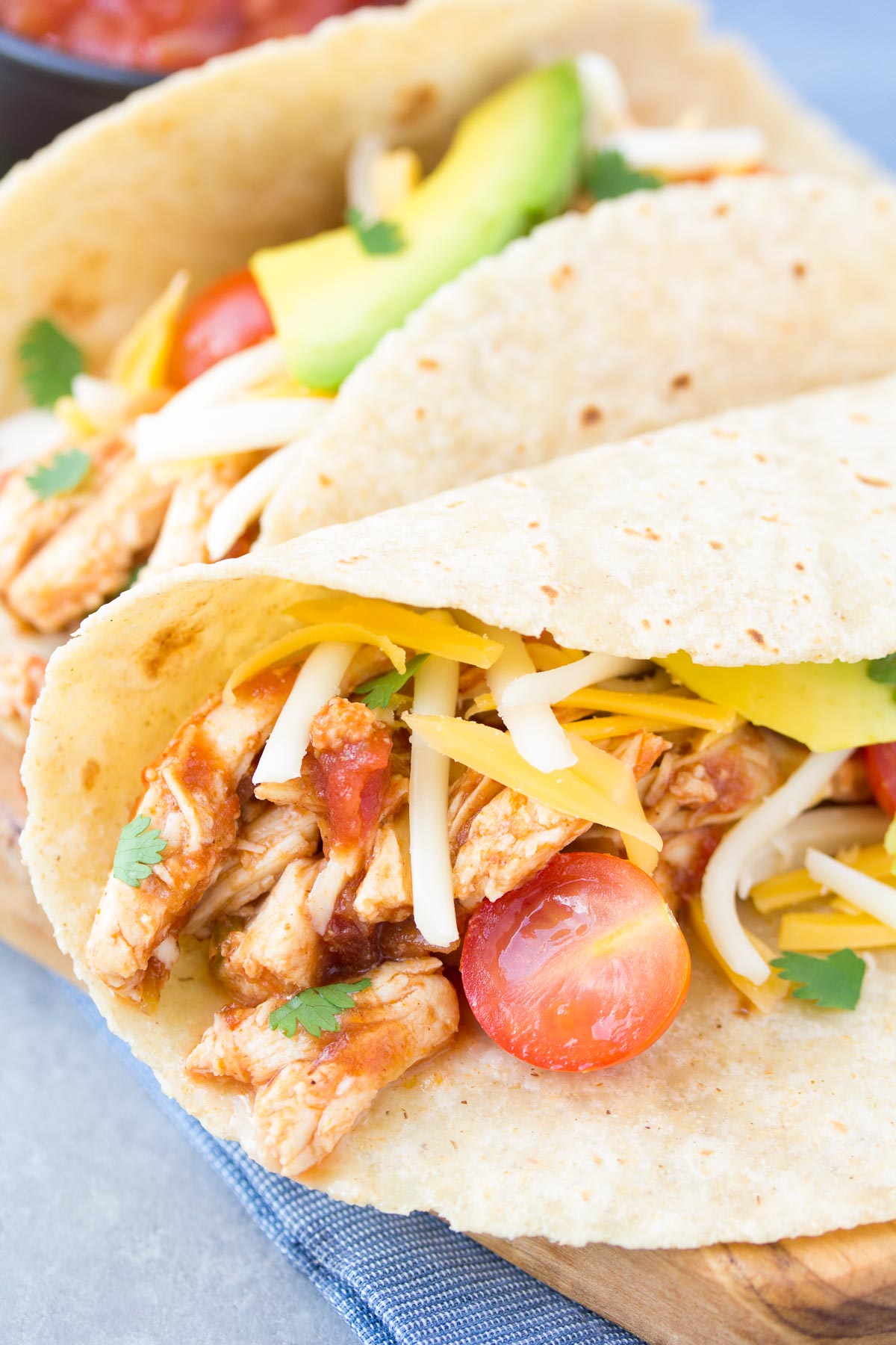 Shredded chicken tacos with salsa, cheese and avocado.