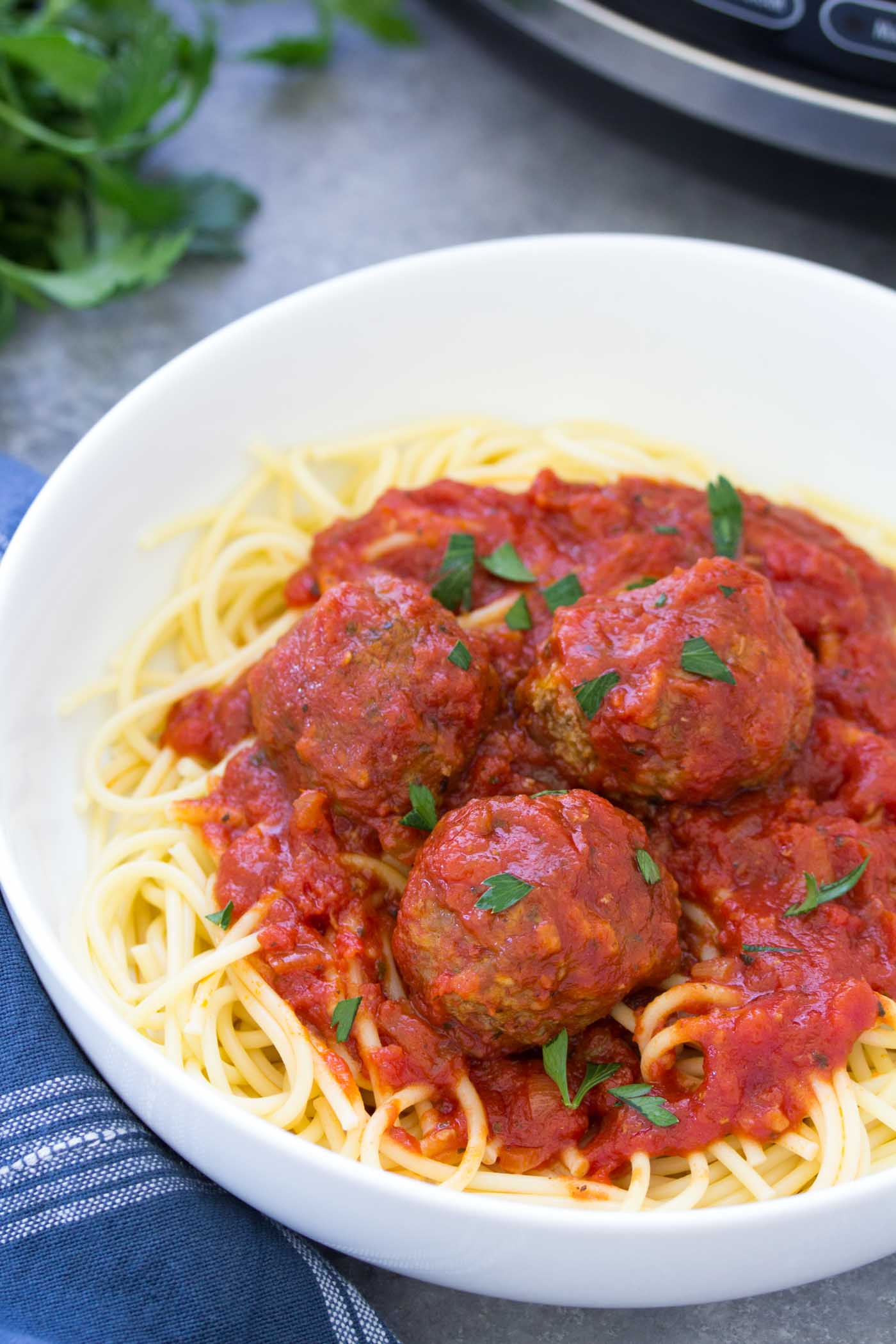 Meatballs and marinara sauce served over spaghetti.