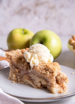 Slice of Dutch apple pie topped with a scoop of vanilla ice cream.