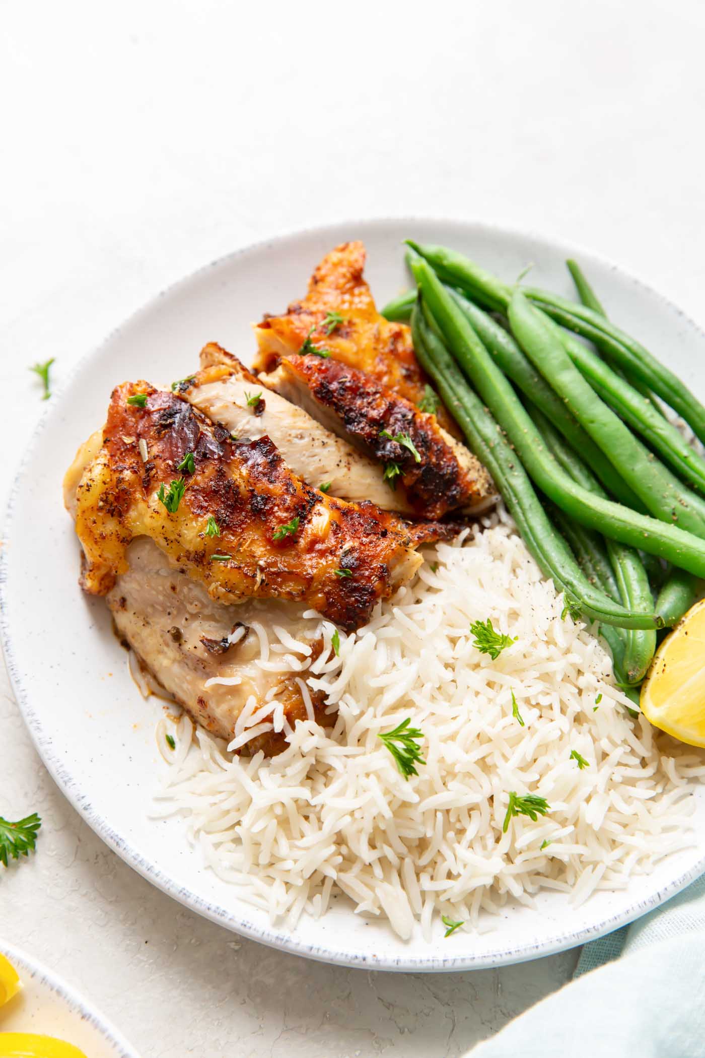 Air fryer chicken thigh served with white rice and green beans.
