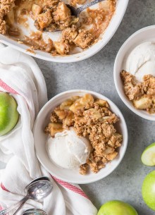 Apple crisp in serving bowls with ice cream.