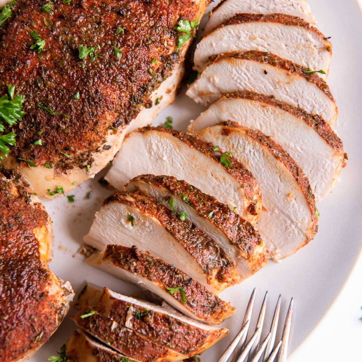 Sliced crockpot chicken breast on a plate.