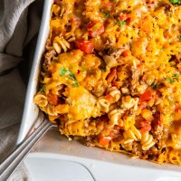 Hamburger casserole in baking dish with serving spoon.