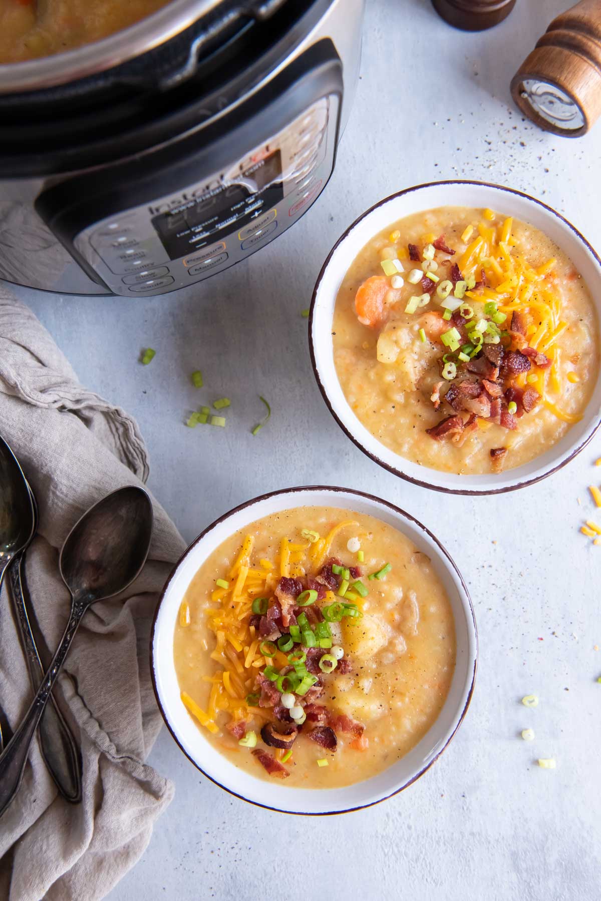 Two bowls of potato soup with instant pot in the background.