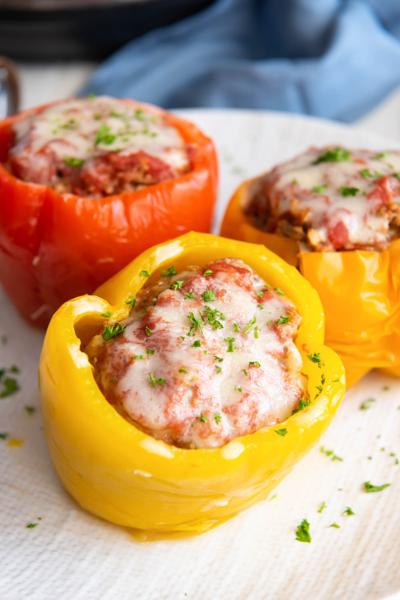Three stuffed peppers on a plate.