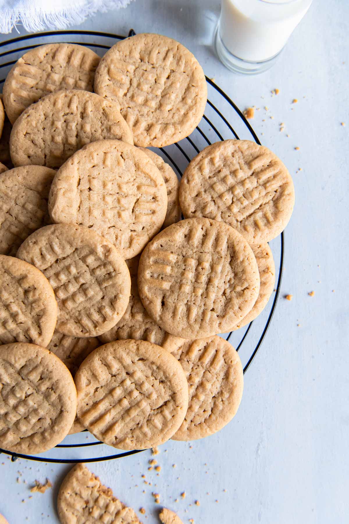 Peanut butter cookies stacked on a round cooling rack.