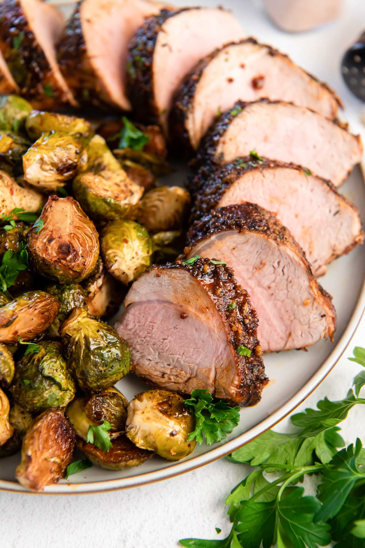 sliced pork tenderloin served with brussels sprouts