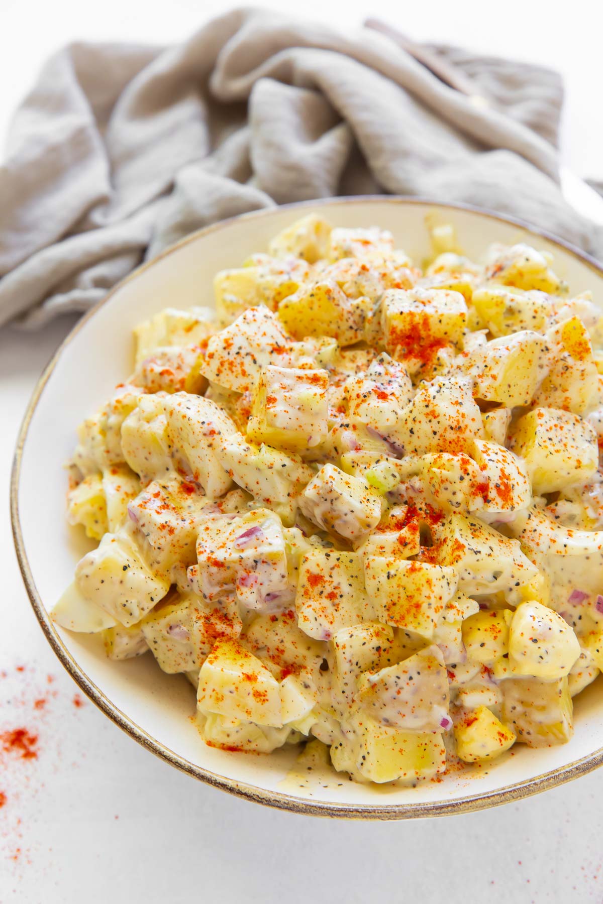 Potato salad with egg and paprika in serving bowl.