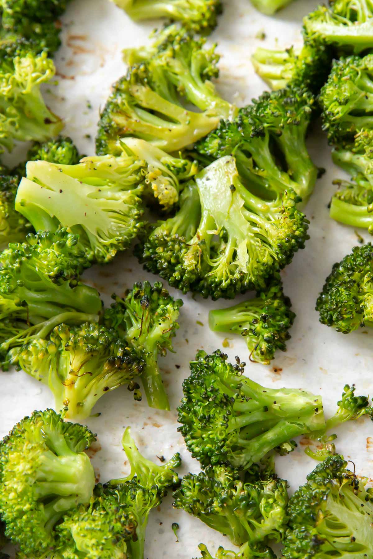 Close up of roasted broccoli on baking sheet.