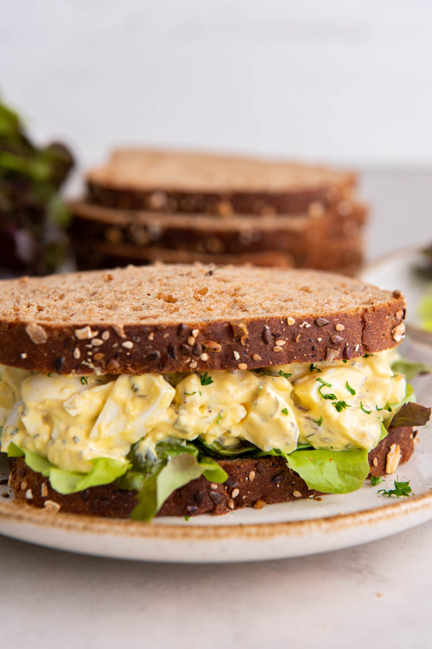 Egg salad sandwich on whole wheat bread with lettuce.