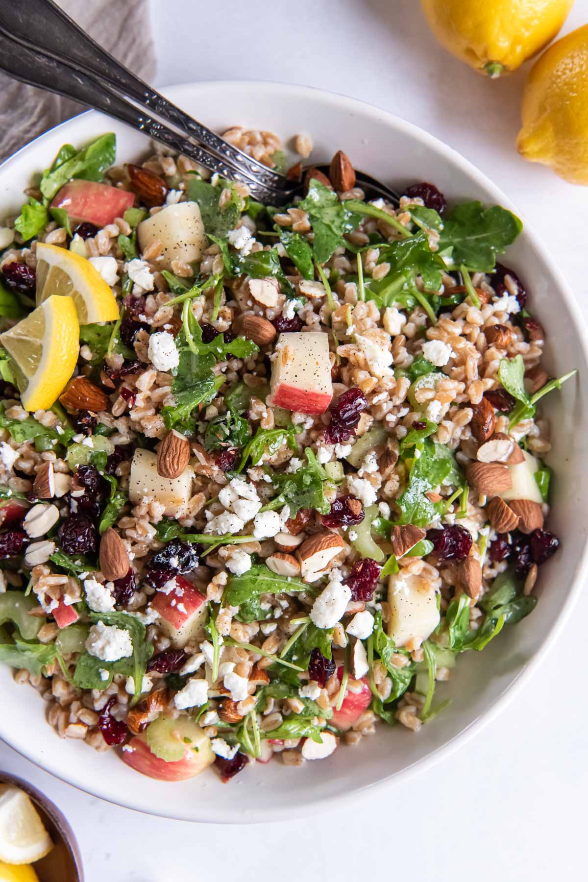 Farro salad with arugula, apple and feta in a serving bowl.