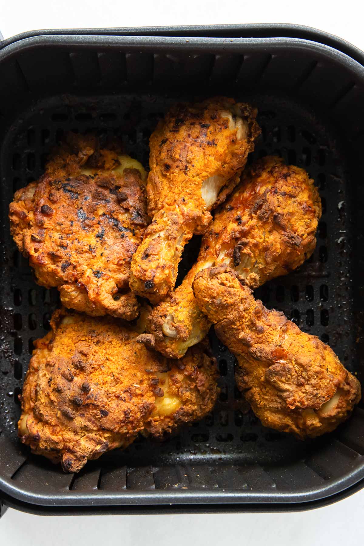 fried chicken legs and thighs in air fryer basket