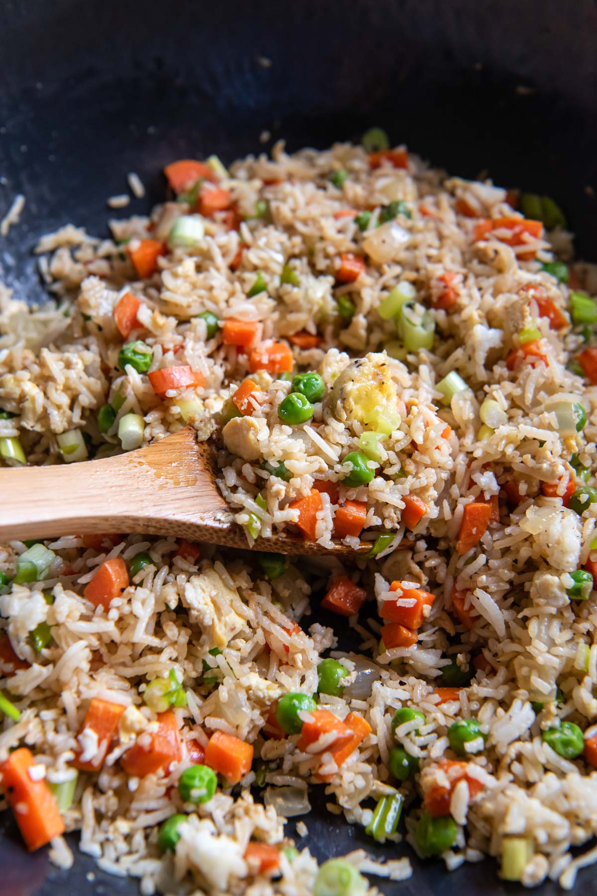 Fried rice in a skillet with a wooden spoon.