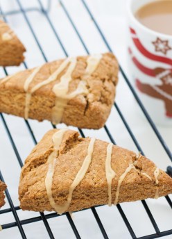 Gingerbread scones with maple glaze on a cooling rack.