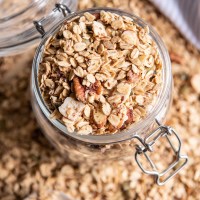 Close up of homemade granola in a glass jar.