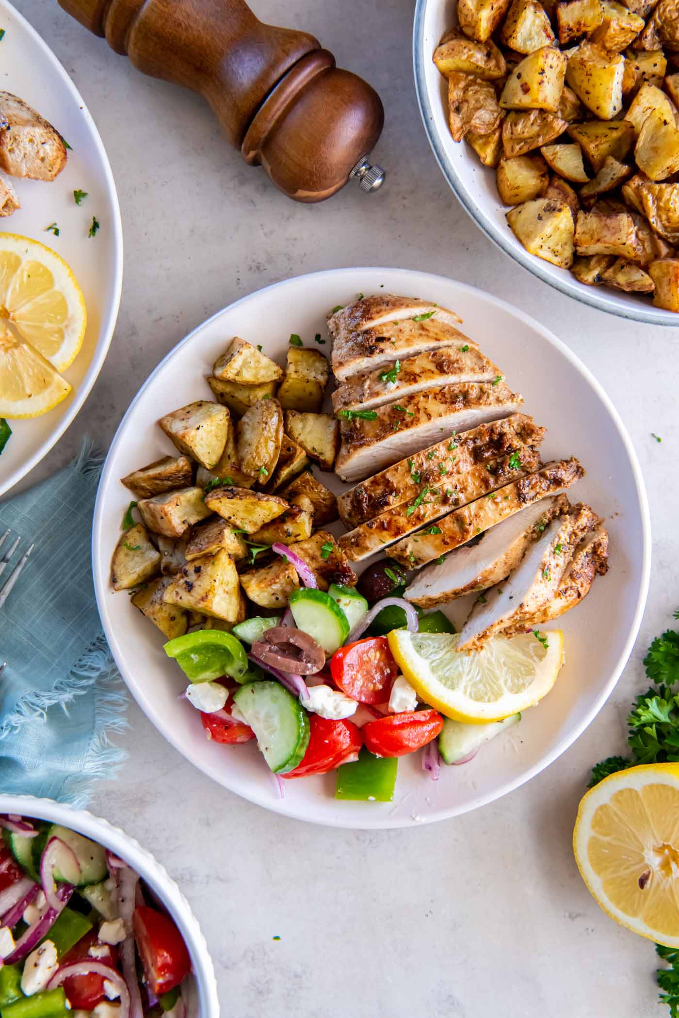 Greek chicken served with roasted potatoes and a Greek salad.