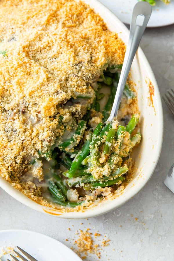 Thanksgiving green bean casserole in a baking dish with a serving spoon.