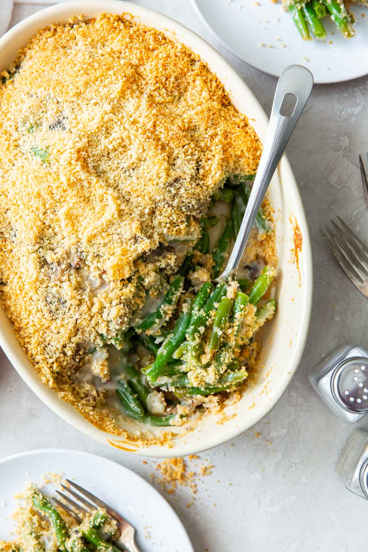 Green bean casserole in a baking dish with a serving spoon.