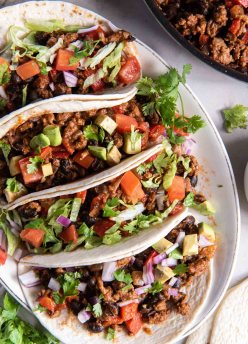 Four ground turkey tacos next to each other on a plate.