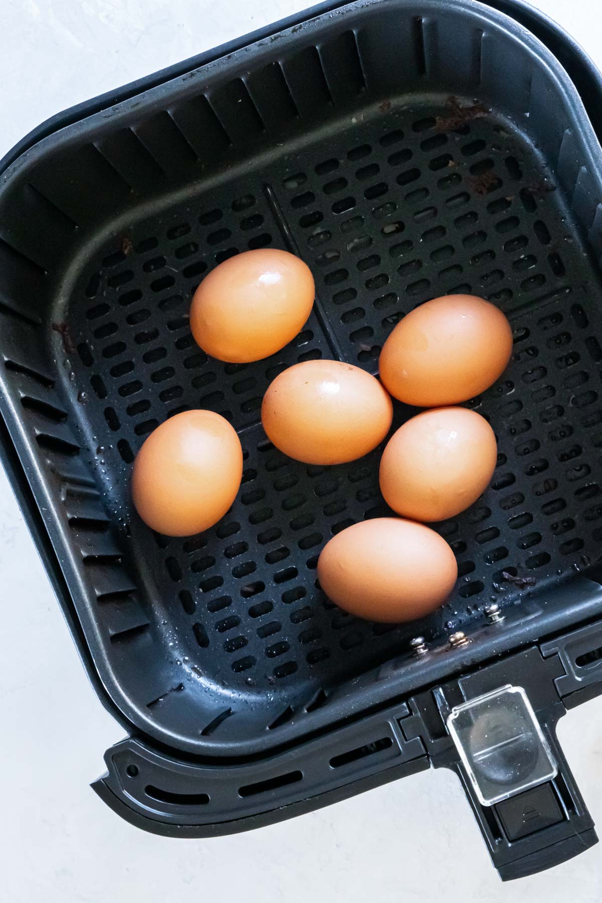 Six hard boiled eggs in an air fryer.
