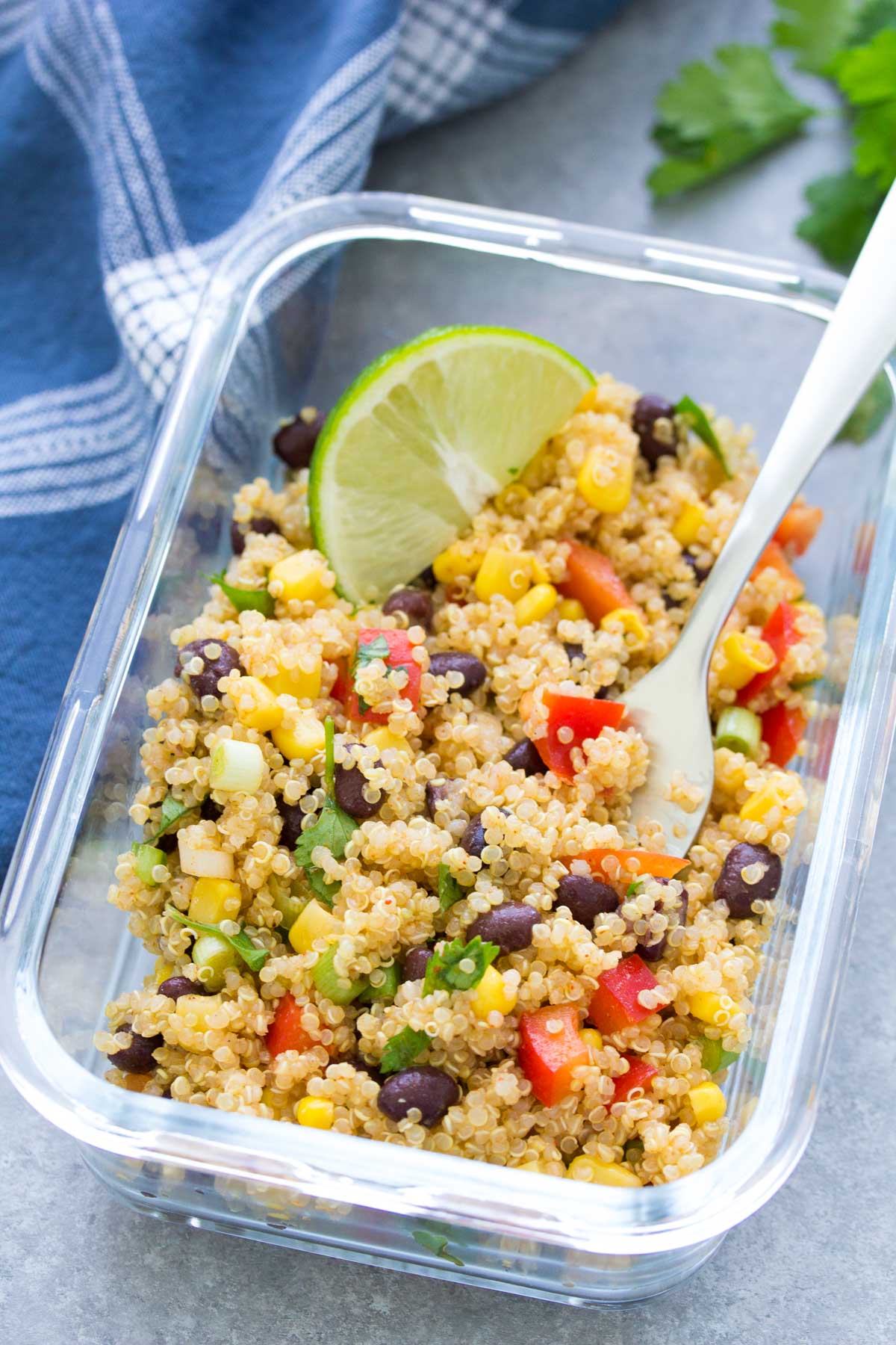 Quinoa salad in meal prep container with a fork.