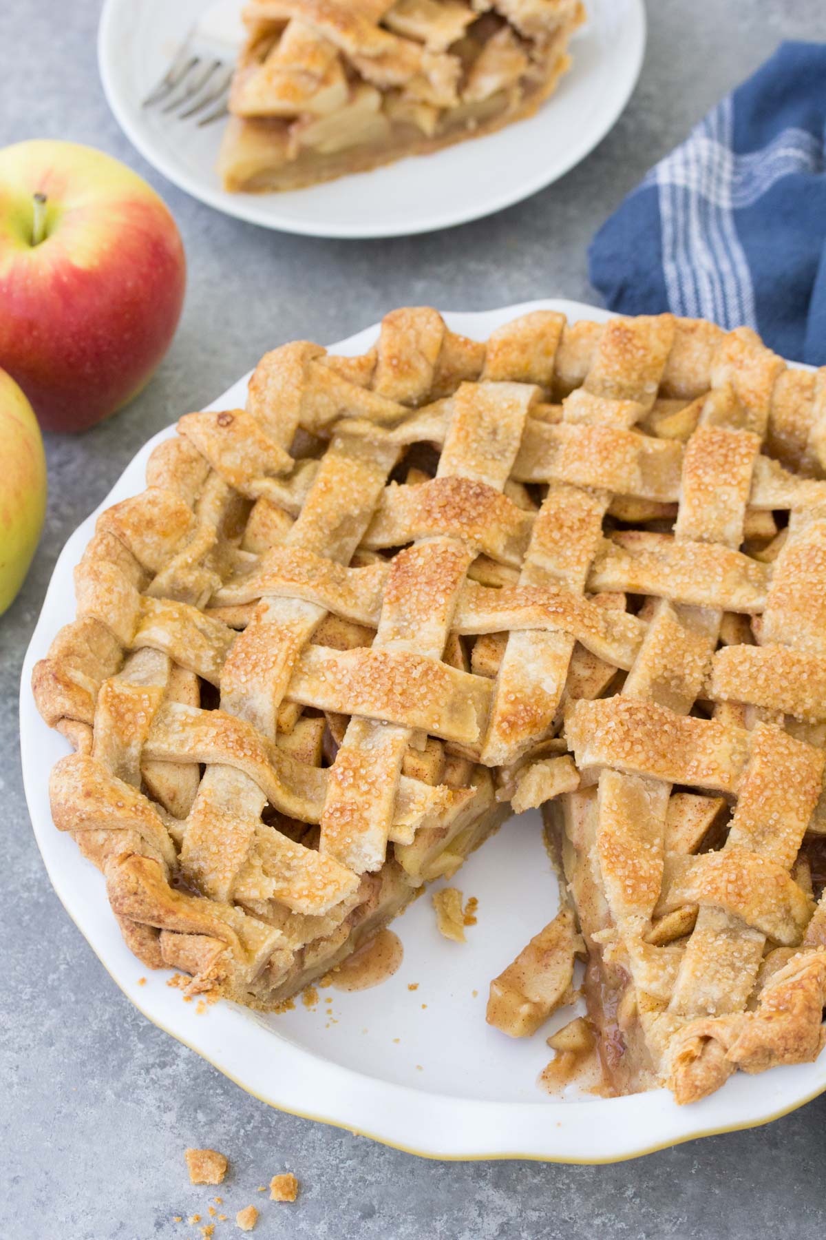 Whole apple pie with one slice removed.