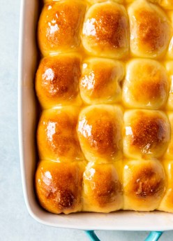 yeast rolls brushed with honey butter in baking dish
