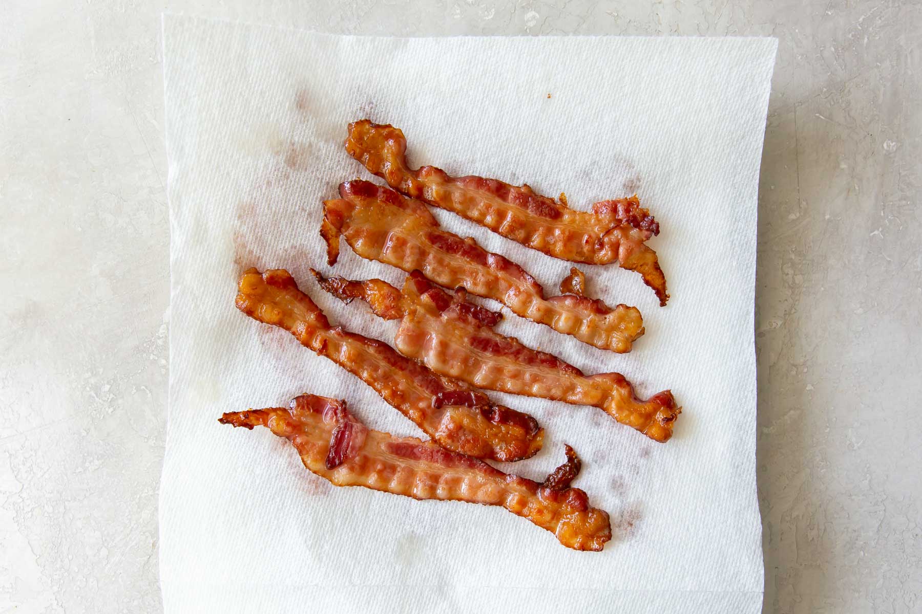 cooked bacon slices on paper towel lined plate