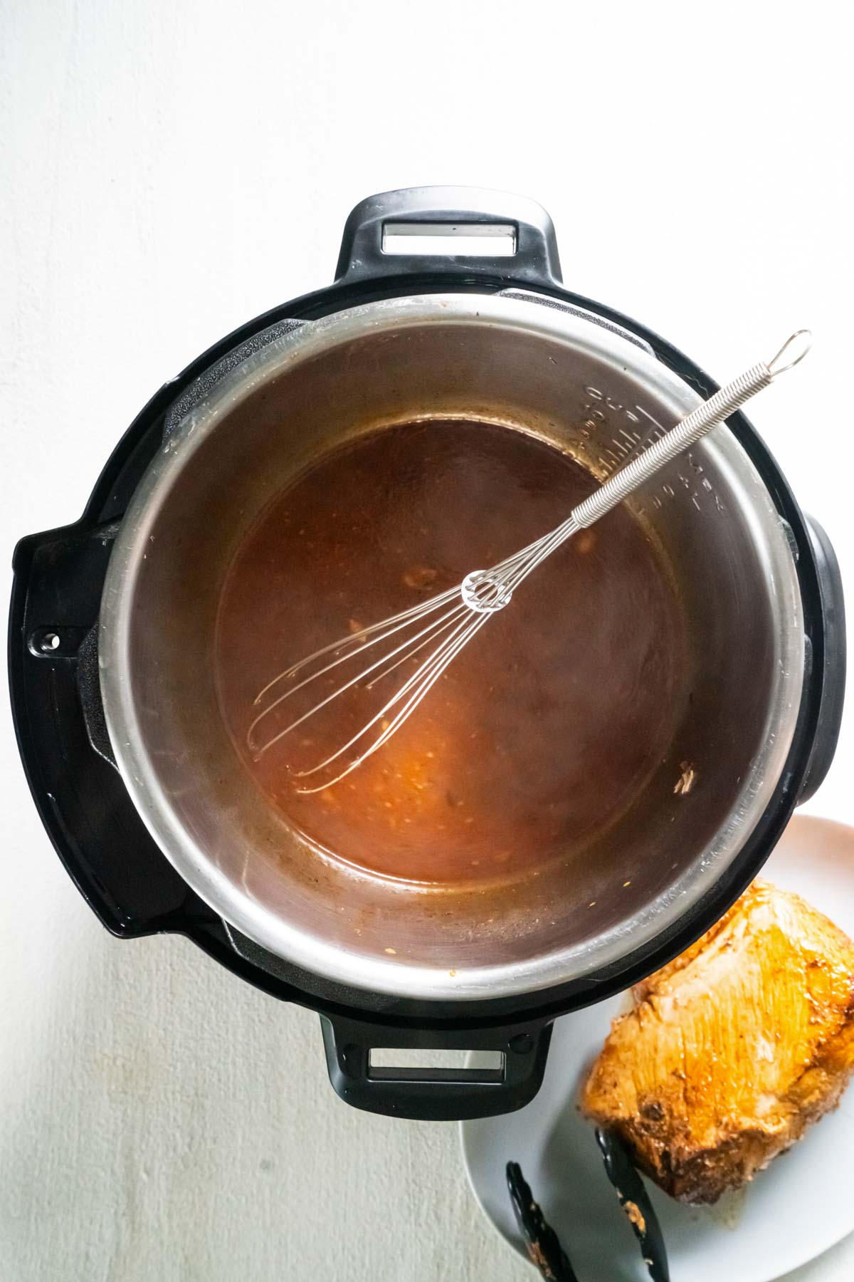 Gravy in instant pot with whisk.