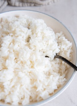 Cooked white rice in a bowl with a spoon.