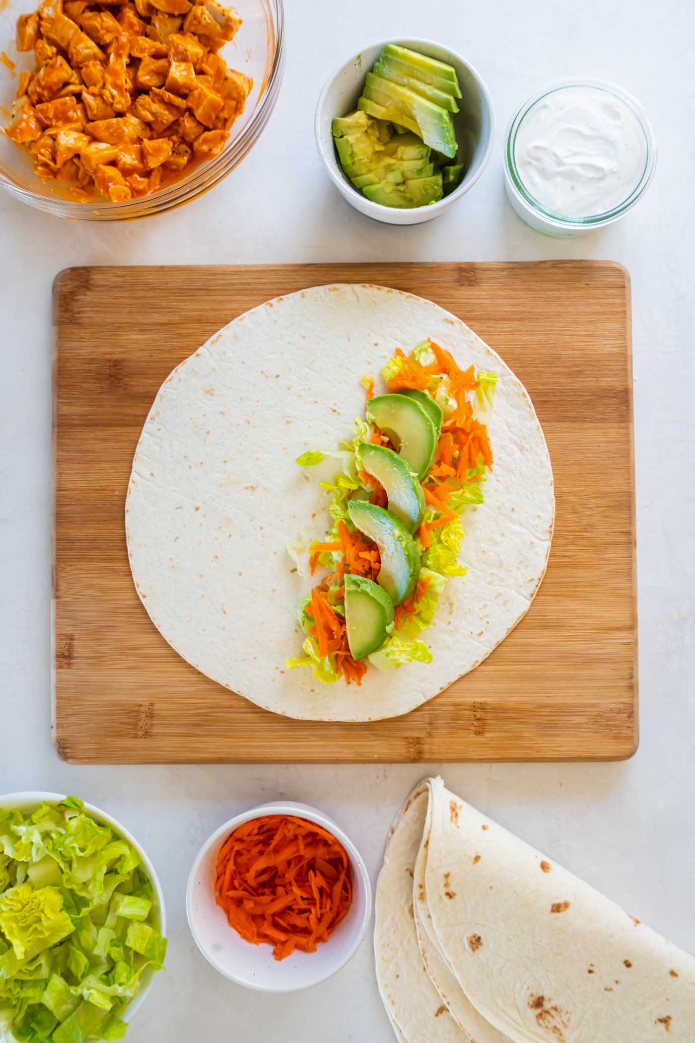 Tortilla with lettuce, shredded carrot and avocado.