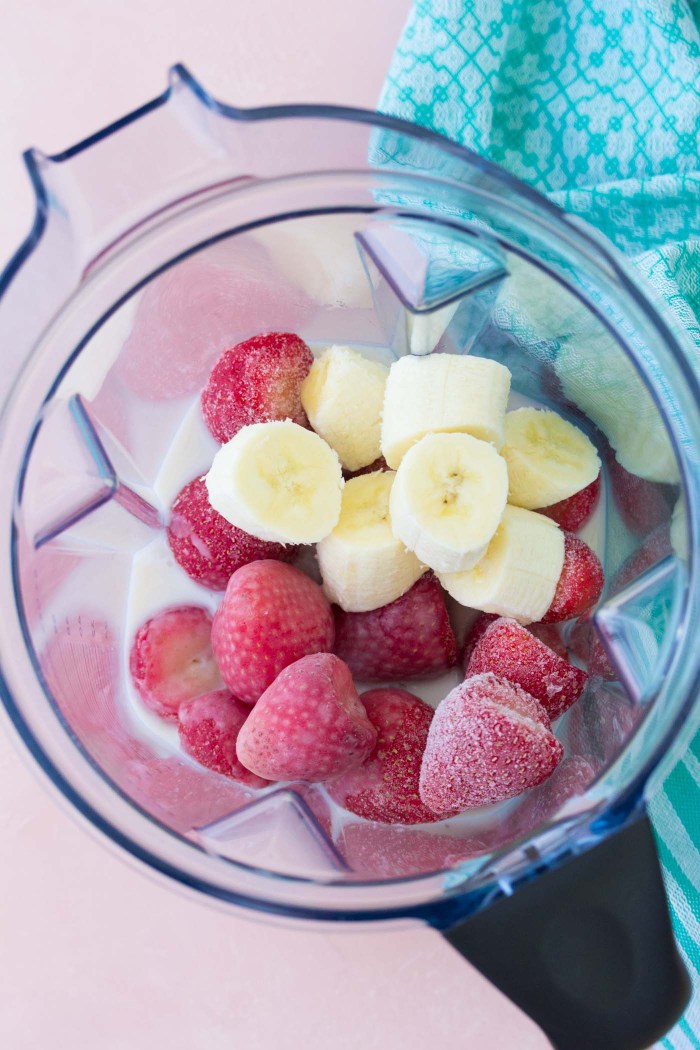 Frozen strawberries, banana, almond milk and Greek yogurt in a blender.