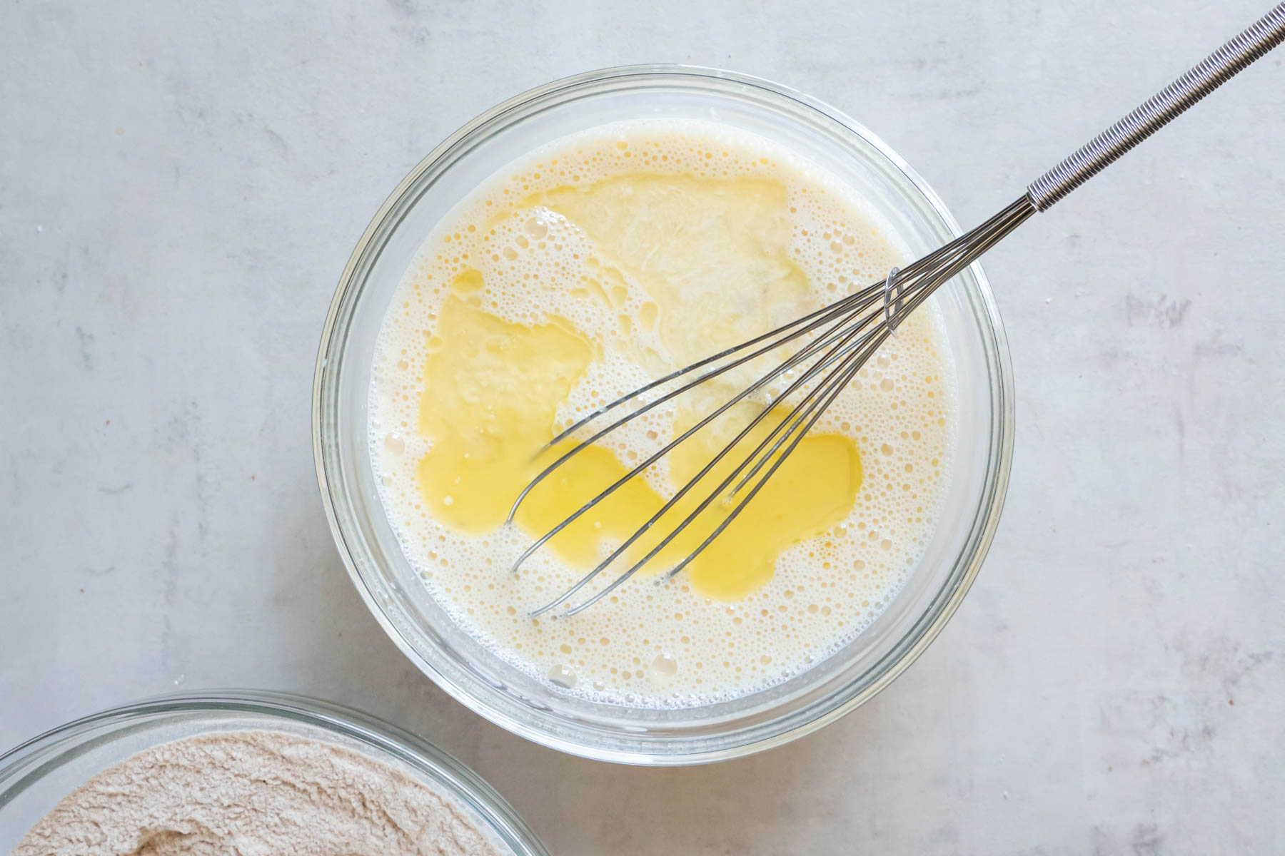 Melted butter added to wet ingredients in mixing bowl.