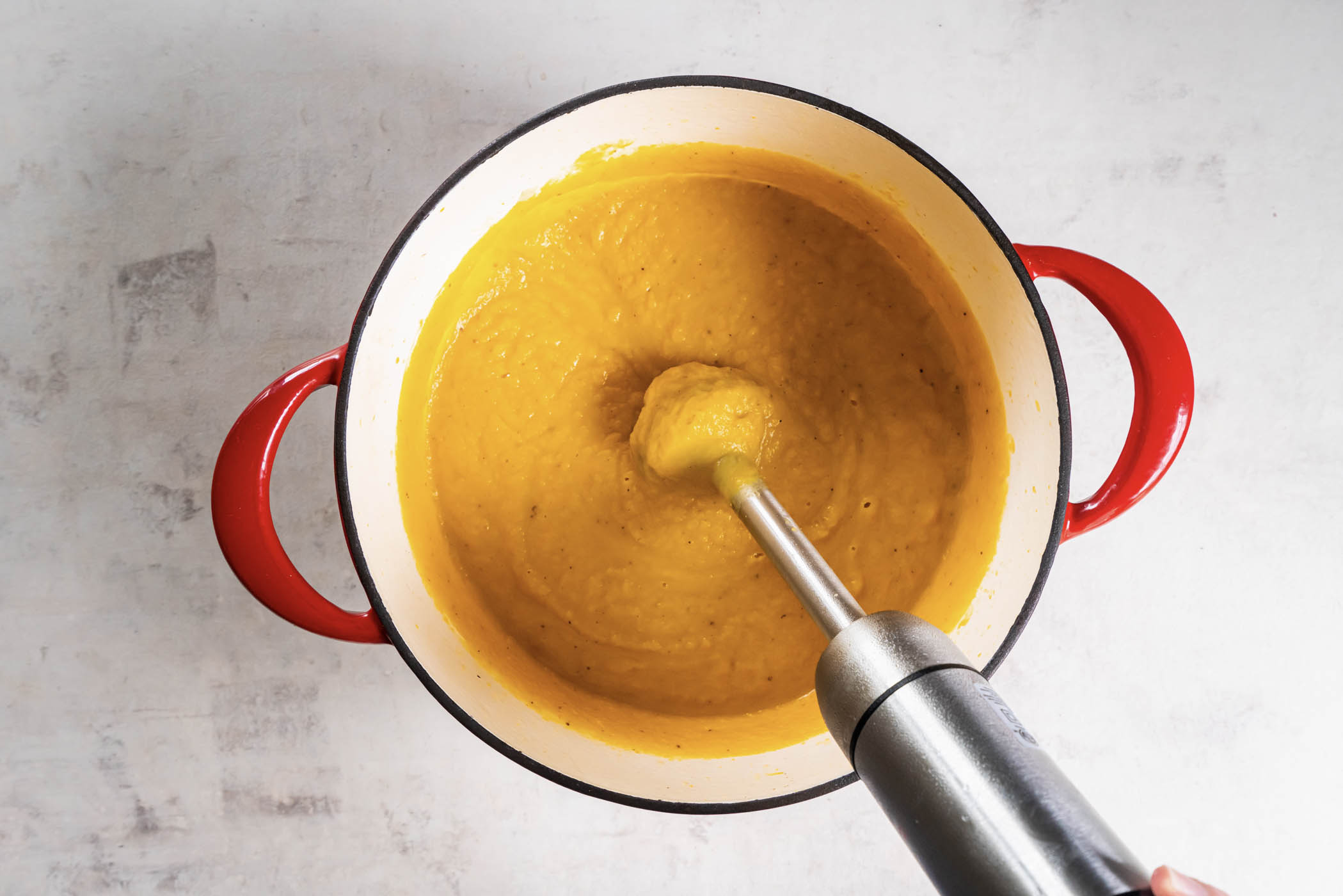 Pureeing soup in pot with an immersion blender.