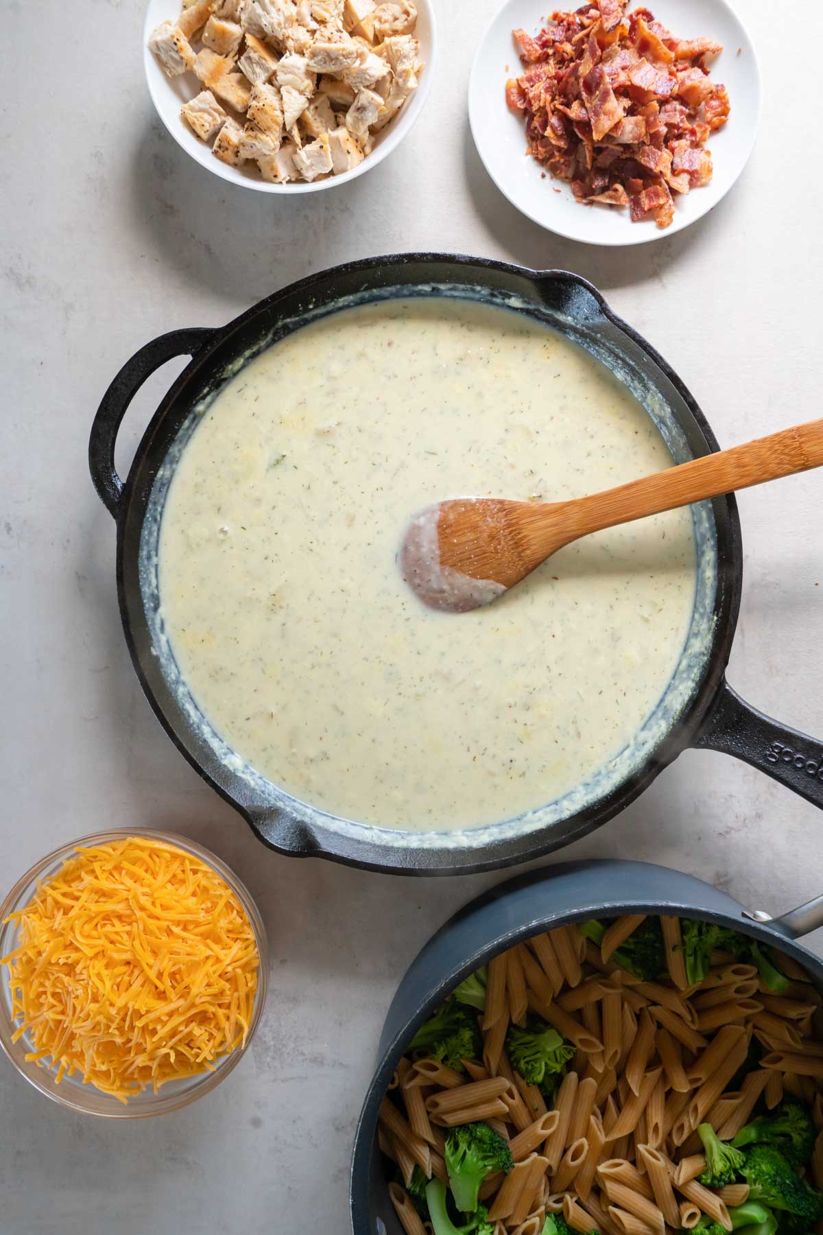 Creamy ranch seasoned sauce in skillet with wooden spoon.