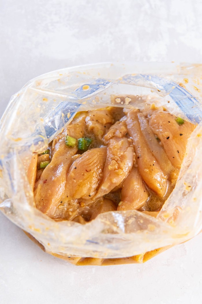Sliced chicken breast strips in a zip-top bag with fajita marinade.