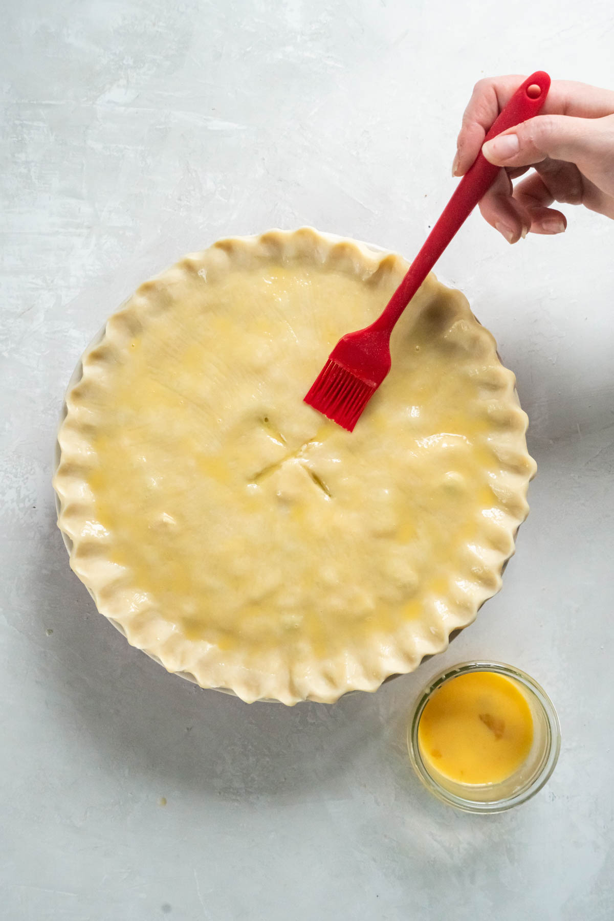 Brushing egg wash on pot pie.