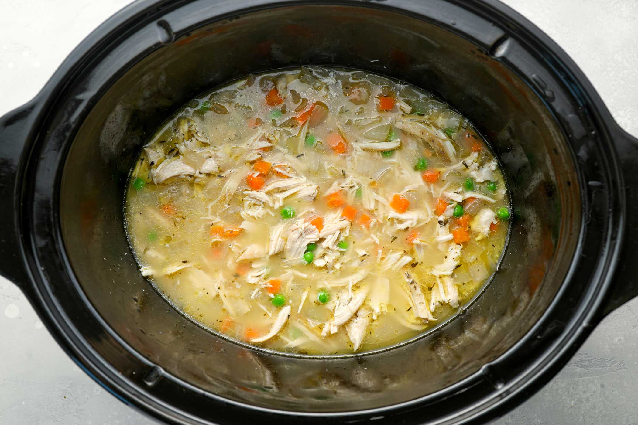 Shredded chicken, frozen vegetables and cornstarch slurry stirred into slow cooker.
