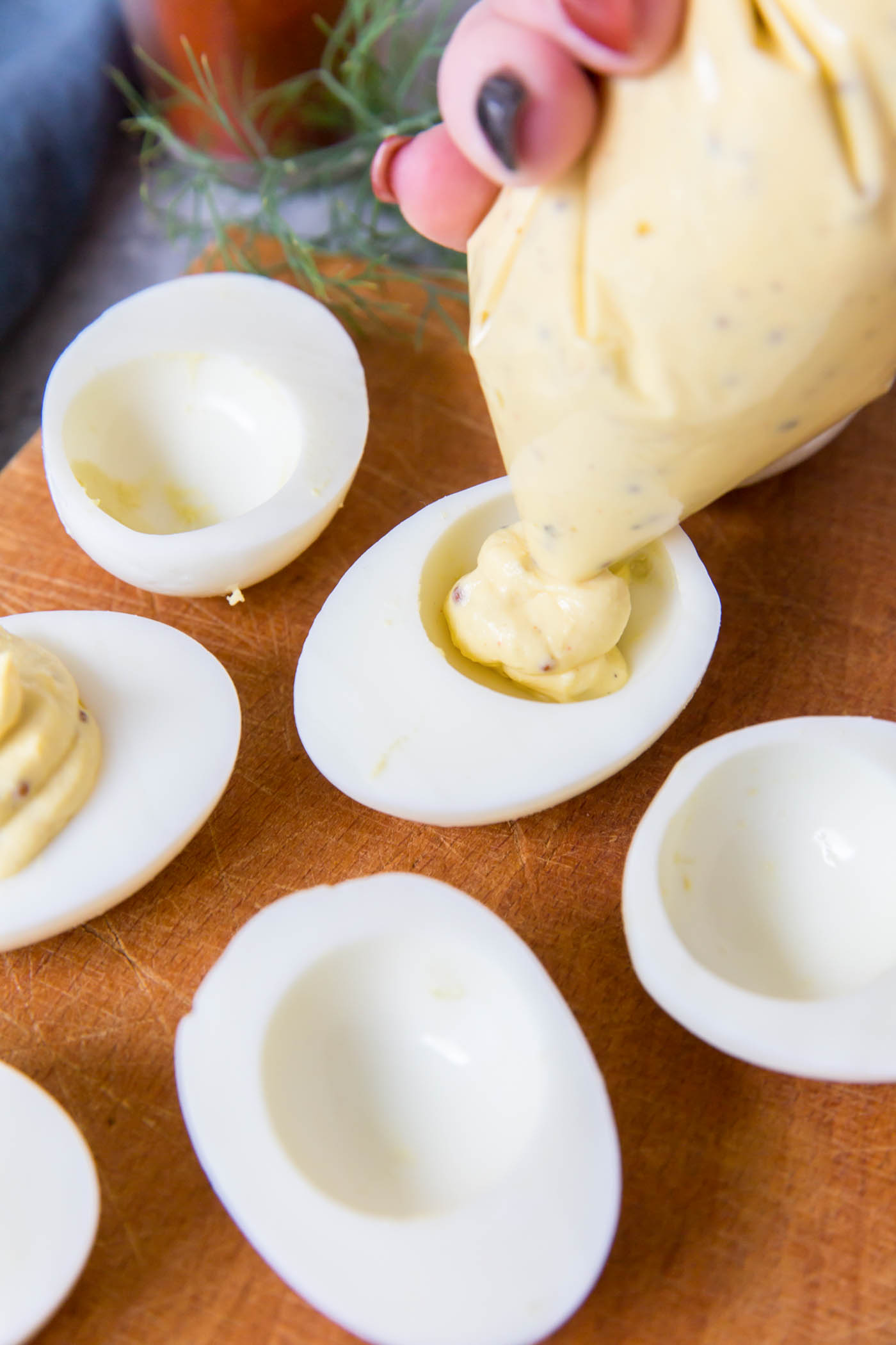 Piping yolk filling into egg whites.