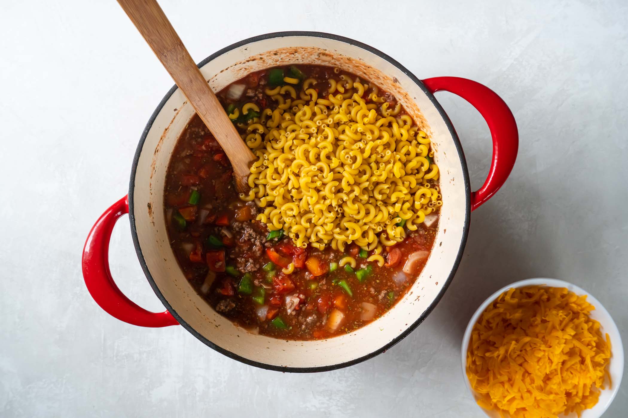 Dry macaroni pasta added to pot.