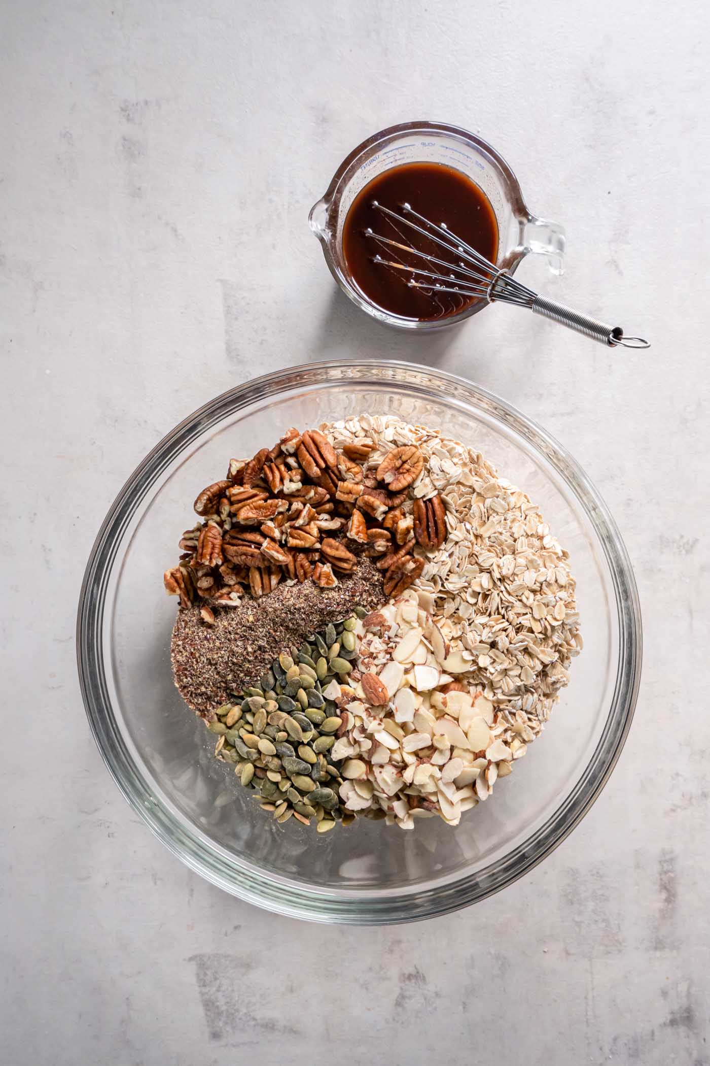 Oats, sliced almonds, pepitas, pecans and flaxseed in mixing bowl.