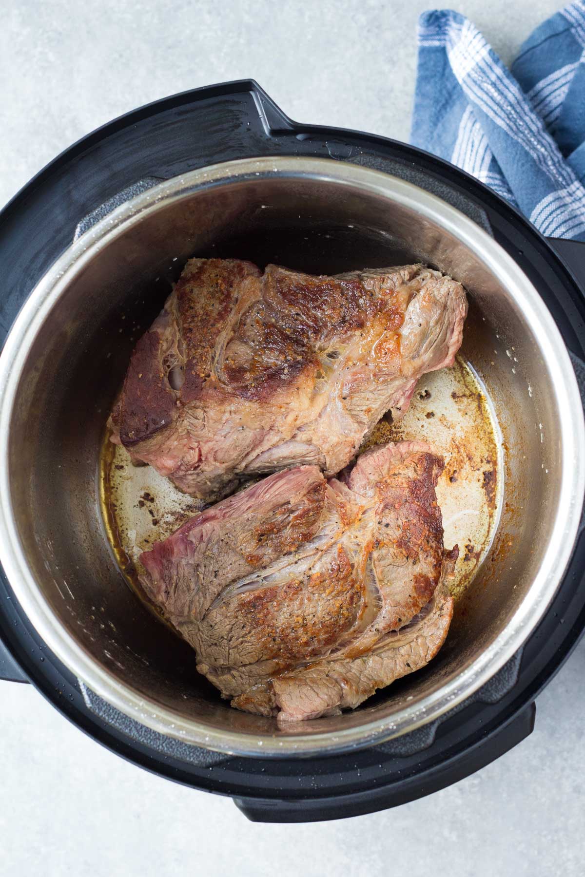 Two pieces of chuck roast browned in an instant pot.