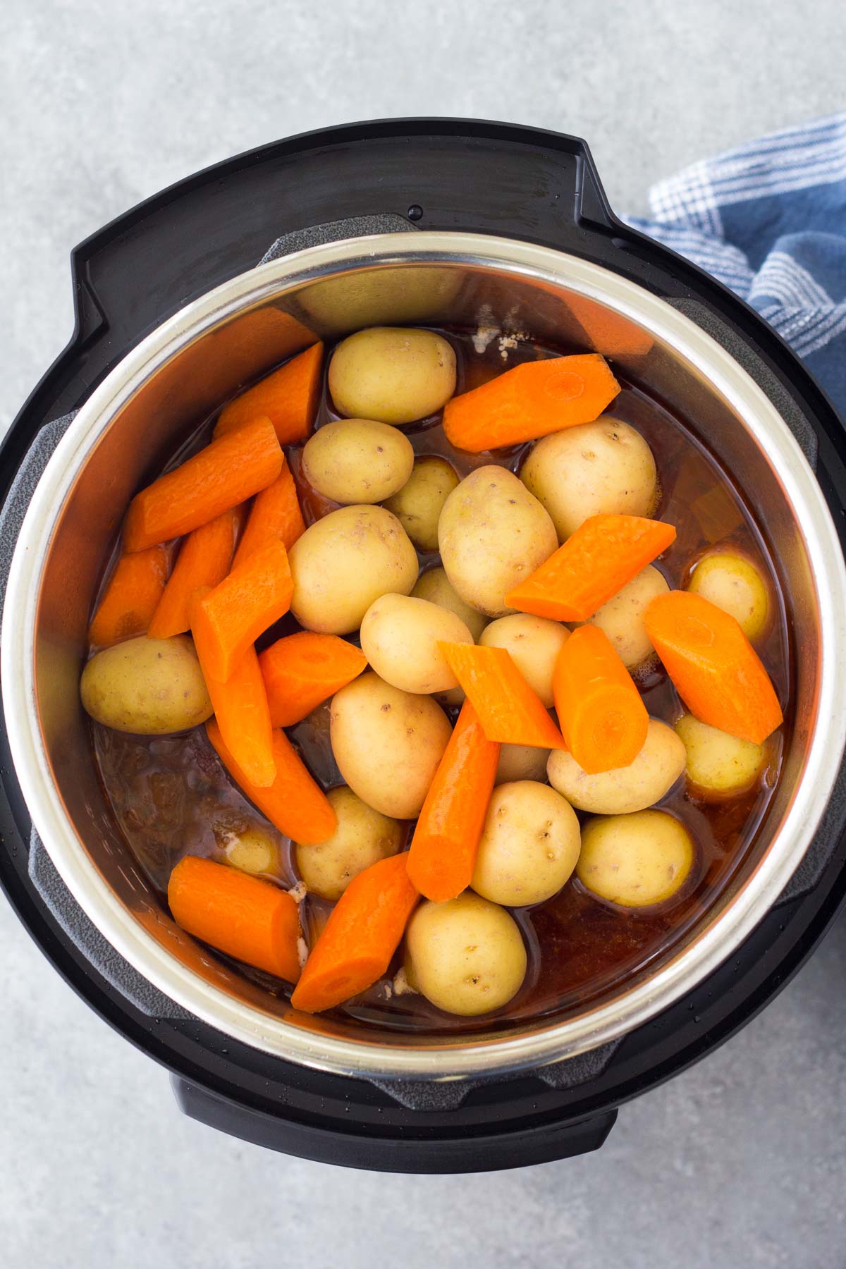 Baby potatoes and carrots added to instant pot.