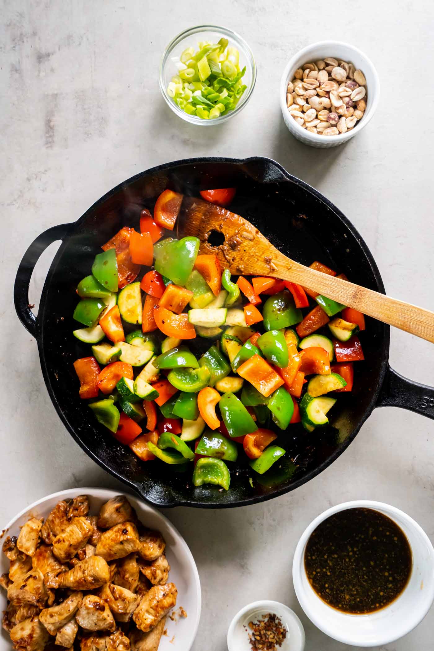 Stir fried bell peppers and zucchini in skillet.