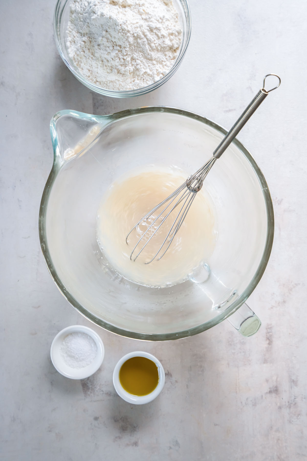 Warm water, yeast and sugar whisked together in mixer bowl.