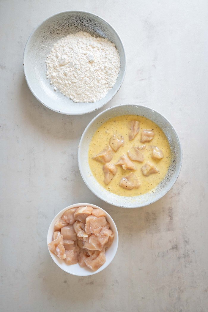 Coating chicken pieces in egg and cornstarch mixture.