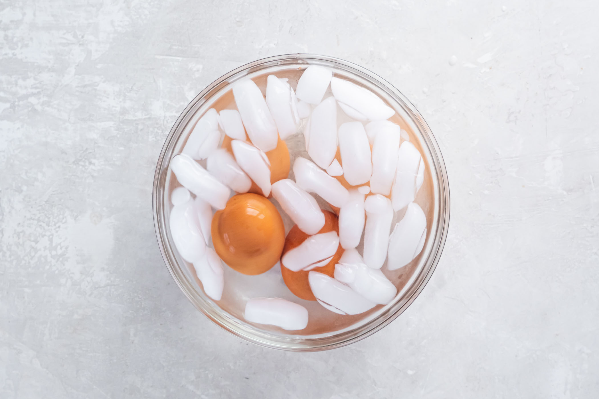 Four eggs in bowl of ice water.