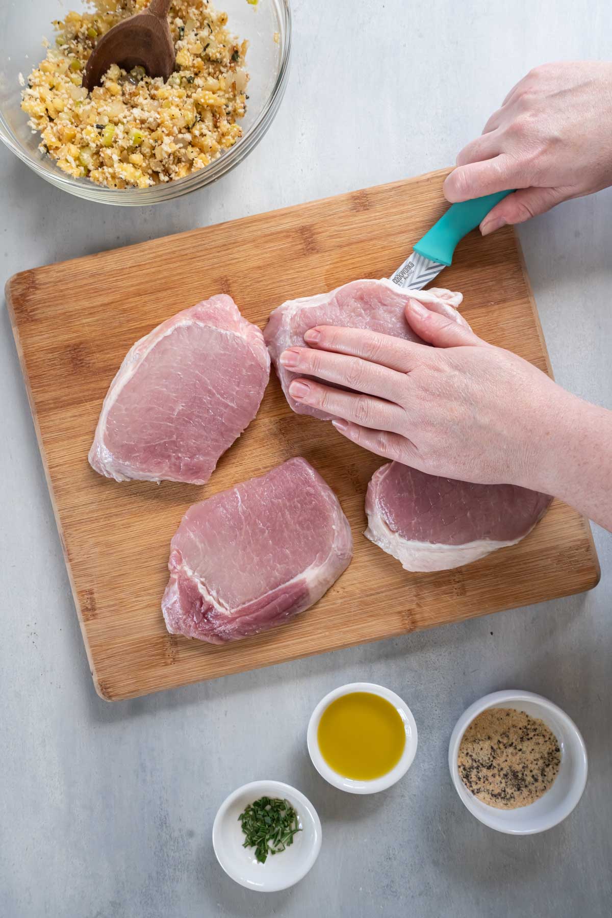 Using knife to cut a pocket in boneless pork chop.